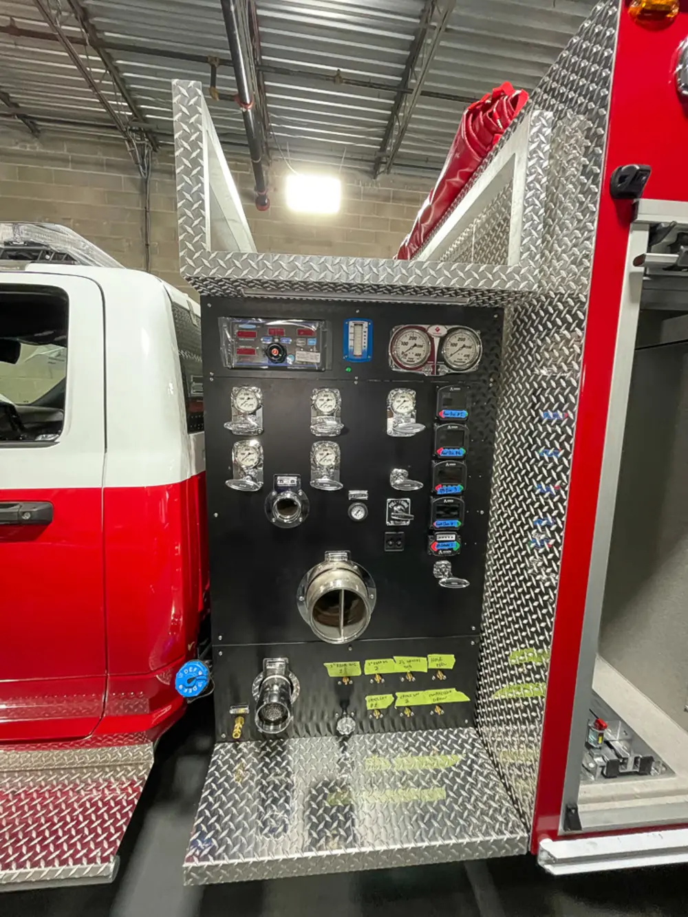 Exterior view of small fire truck showing cab, body compartments, and wheel/tire area.